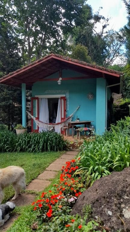 Chalé Turquesa com rede na varanda, entre o jardim